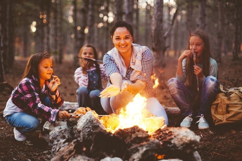 Group of kids with mom sitting by the fire